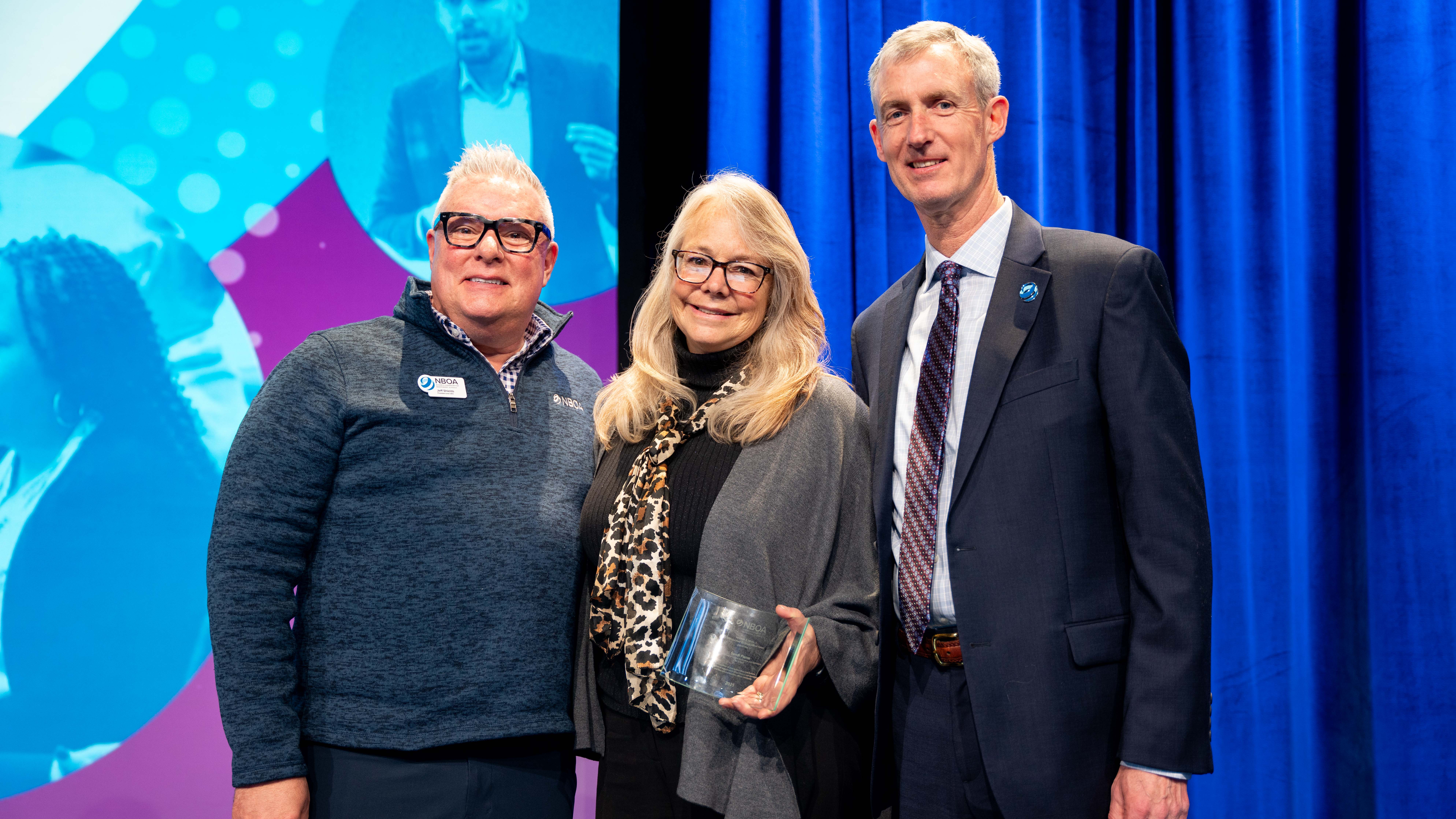 Jeff Shields, Sandi Pierce and Duncan Booth as Pierce receives the Distinguished Business Officer Award