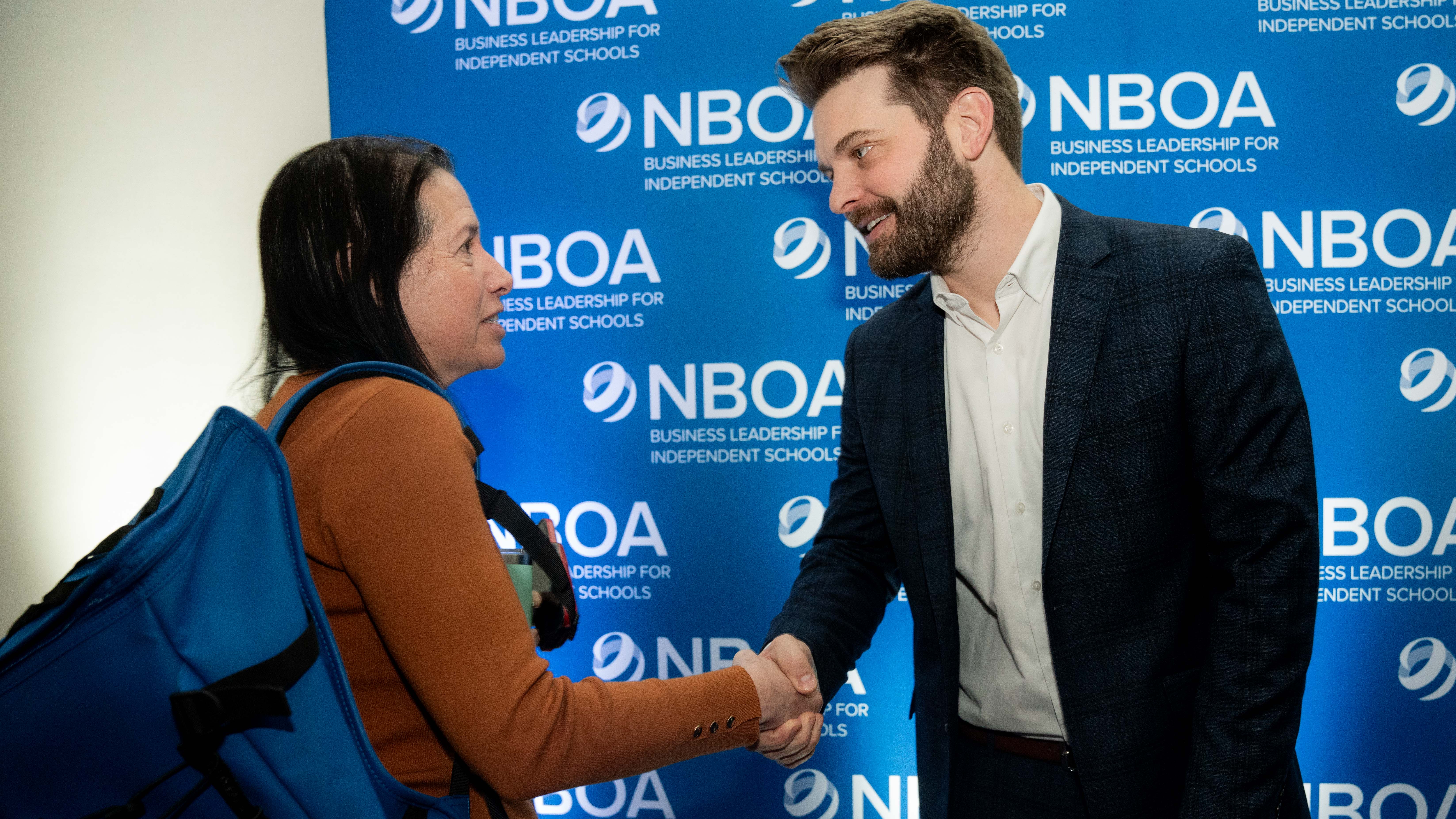 Kyle Scheele shakes hands with attendee at 2025 NBOA Annual Meeting