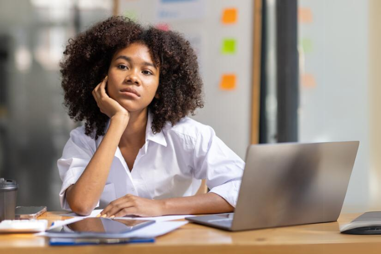 Woman thinking at her computer.